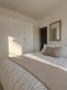 a bedroom with a large bed and a mirror at NØ -Central Apartment Odense C in Odense