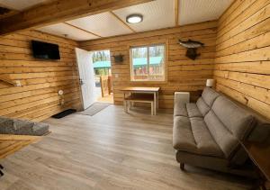 a living room with a couch and a table at Sockeye Salmon Sanctuary, Cabin 6 at Lower Kenai Lodge in Kenai