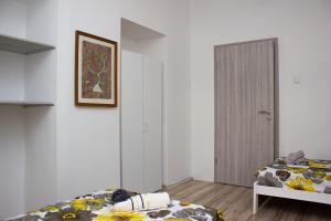 ein Schlafzimmer mit zwei Betten und einer Tür zu einem Zimmer in der Unterkunft Hostel Centuria in Pula
