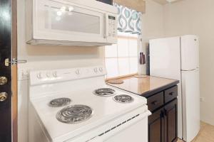 a kitchen with a white stove and a microwave at Family Getaway Suite at Hummingbird Home Suites Gold Standard Certified in San Pedro