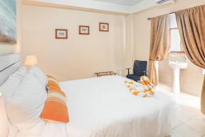 a bedroom with a white bed and a sink at Family Getaway Suite at Hummingbird Home Suites Gold Standard Certified in San Pedro +13 photos