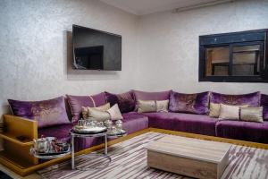 a living room with a purple couch and a table at dakhla home in Aït Krad