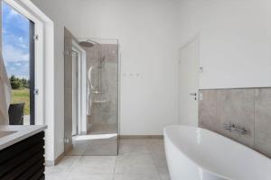 a white bathroom with a tub and a shower at TV1737-Bindslev-Mellemklitvej-23 in Tversted +23 photos