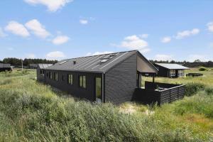 a black house in the middle of a field at TV1737-Bindslev-Mellemklitvej-23 in Tversted