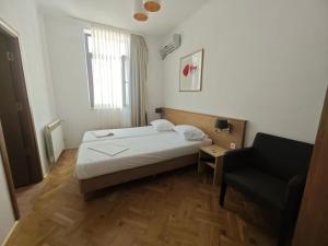 a hotel room with a bed and a chair at Ralf Residence in Bucharest +34 photos