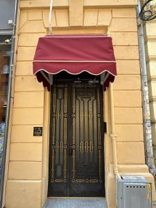 a black door with a purple awning on a building at Ralf Residence in Bucharest