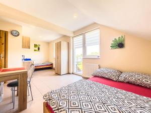 a bedroom with a bed and a desk and a window at Pensjonat Viki in Sarbinowo