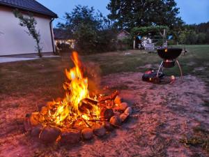 a fire pit with a grill in a yard at Siedlisko Stasin in Trojanów