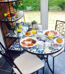 a table with breakfast foods and drinks on it at Stepping Stones B&B in Lymington