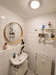 a white bathroom with a sink and a mirror at Modern Comfort Apartment with Balcony in Dresden