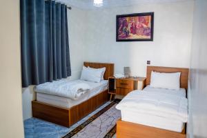 a room with two beds and a desk and a window at dakhla home in Aït Krad