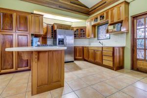a large kitchen with wooden cabinets and a refrigerator at Suite at Villa Maya -Gold Standard and Certified in San Ignacio
