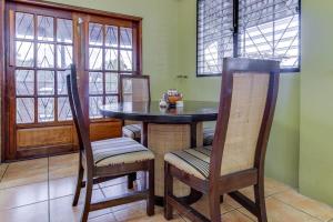 a dining room with a table and chairs and windows at Suite at Villa Maya -Gold Standard and Certified in San Ignacio +15 photos