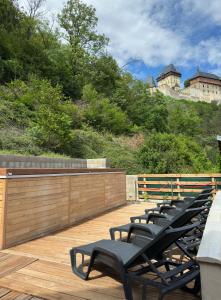 a row of benches sitting on a wooden deck at Wellness apartment Karlštejn in Karlštejn