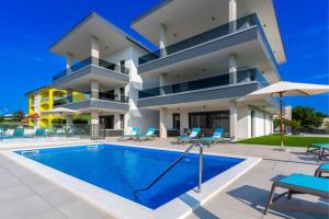a villa with a swimming pool in front of a building at Penthouse Apartment Maya with Pool and Jacuzzi in Sveti Anton