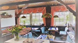 a dining room with chairs and tables and windows at Hotel Dümptener Hof in Mülheim an der Ruhr