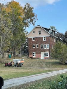a tractor parked in front of a large brick house at Esplanade at Clear Lake in Waseca