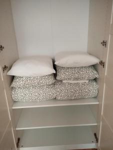 two pillows sitting on shelves in a closet at Royal Apartment in Rumia +8 photos