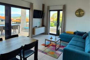 a living room with a blue couch and a table at Penthouse Apartment Maya with Pool and Jacuzzi in Sveti Anton