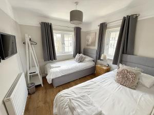 a bedroom with two beds and a flat screen tv at Barn Cottage in Minehead