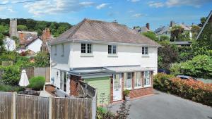 a white house with a green garage next to a fence at Barn Cottage in Minehead