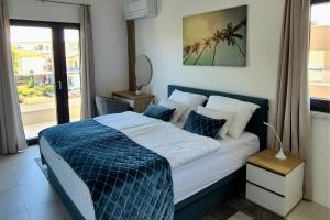 a bedroom with a blue and white bed with a window at Penthouse Apartment Maya with Pool and Jacuzzi in Sveti Anton +73 photos
