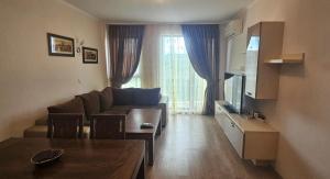 a living room with a couch and a table at Sun Sea App in Shkorpilovtsi