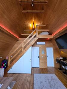 an attic room with a staircase in a house at Cabana BBO - Jacuzzi, TV and Terasse in Colibiţa