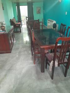 a dining room with a wooden table and chairs at Departamento amplio in Fernando de la Mora
