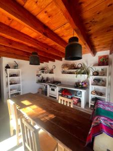 ein Esszimmer mit einem Tisch und einer Küche in der Unterkunft Maima in Maimará