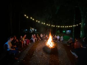 a group of people sitting around a fire at night at Espaço Luna in Gramado +21 photos