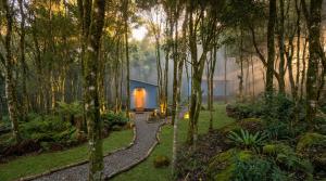 a house in the middle of a forest with a walkway at Espaço Luna in Gramado