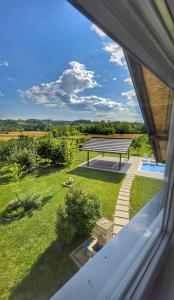 a view from a window of a yard with a bench at Sunny Funny House in Čačak