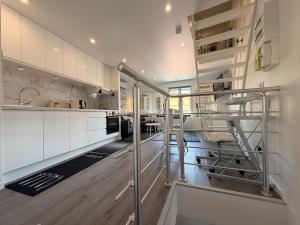 a kitchen with white cabinets and a staircase in it at *Climatisé* Duplex en hyper centre refait à neuf in Le Puy-en-Velay