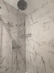 a bathroom with a shower with white marble walls at *Climatisé* Duplex en hyper centre refait à neuf in Le Puy-en-Velay
