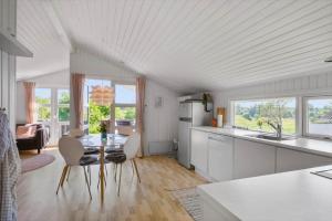 a kitchen and living room with a table and chairs at JB507-Fjerritslev-Perikumvej-50 in Slettestrand +23 photos