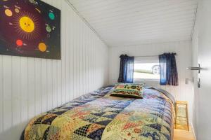 a bedroom with a bed with a colorful quilt at JB507-Fjerritslev-Perikumvej-50 in Slettestrand