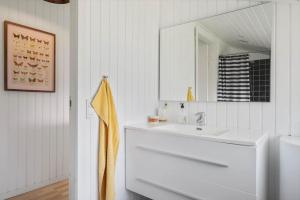 a white bathroom with a sink and a mirror at JB507-Fjerritslev-Perikumvej-50 in Slettestrand