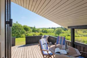 a wooden deck with a table and chairs on it at JB507-Fjerritslev-Perikumvej-50 in Slettestrand