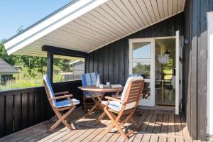 a patio with a table and chairs on a deck at JB507-Fjerritslev-Perikumvej-50 in Slettestrand
