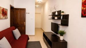 a living room with a red couch and a television at Sliema central apartment in Sliema