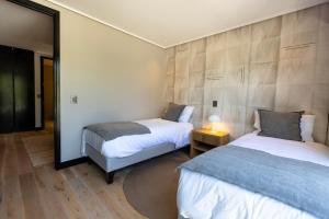 a bedroom with two beds and a mirror at At Home Alonso in Santiago