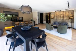 a dining room and living room with a black table and chairs at At Home Alonso in Santiago