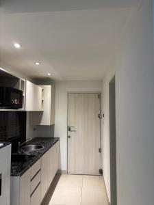 a kitchen with a door leading into a kitchen with a sink at Bnb loft XlV - Pasos Bv oroño y Av pellegrini in Rosario