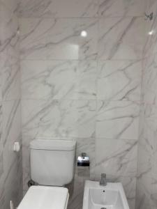 a white bathroom with a toilet and a sink at Bnb loft XlV - Pasos Bv oroño y Av pellegrini in Rosario