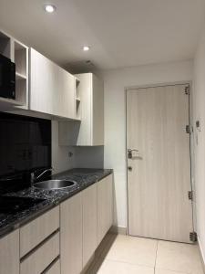 a kitchen with a door leading to a sink at Bnb loft XlV - Pasos Bv oroño y Av pellegrini in Rosario +8 photos