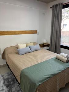 a bedroom with a large bed with a window at Bnb loft XlV - Pasos Bv oroño y Av pellegrini in Rosario