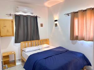 a bedroom with a bed with blue sheets and a window at Leonessa's Villa in Dahab