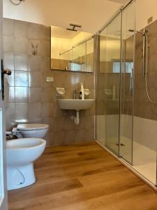 a bathroom with a toilet and a sink and a shower at Appartamento Michela in Darzo
