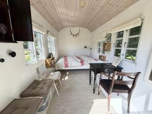 a bedroom with a bed and a desk and a table at Nøddehaven in Eg
